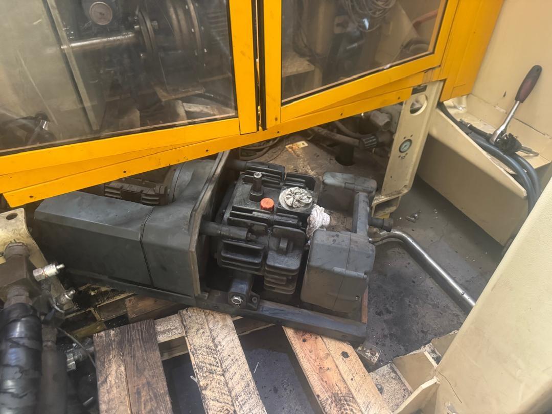 PENCO technicians servicing a hydraulic power unit inside a machine guard enclosure